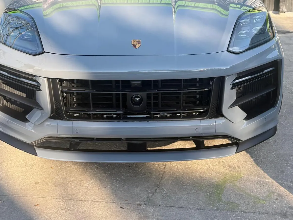 The same Porsche Cayenne with the hood and bumper rebuilt, panels straight and masked, ready for refinishing.